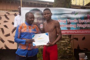 Two male swimming camp participants holding up a certificate.