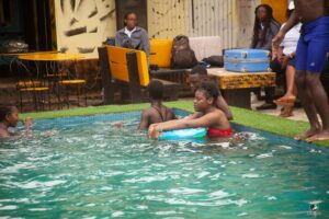 A group of camp participants having fun in the pool and learning to swim in the water during No Limit International's swimming camp.