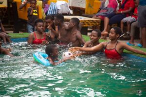 A group of camp participants having fun in the pool and learning to swim in the water during No Limit International's swimming camp.