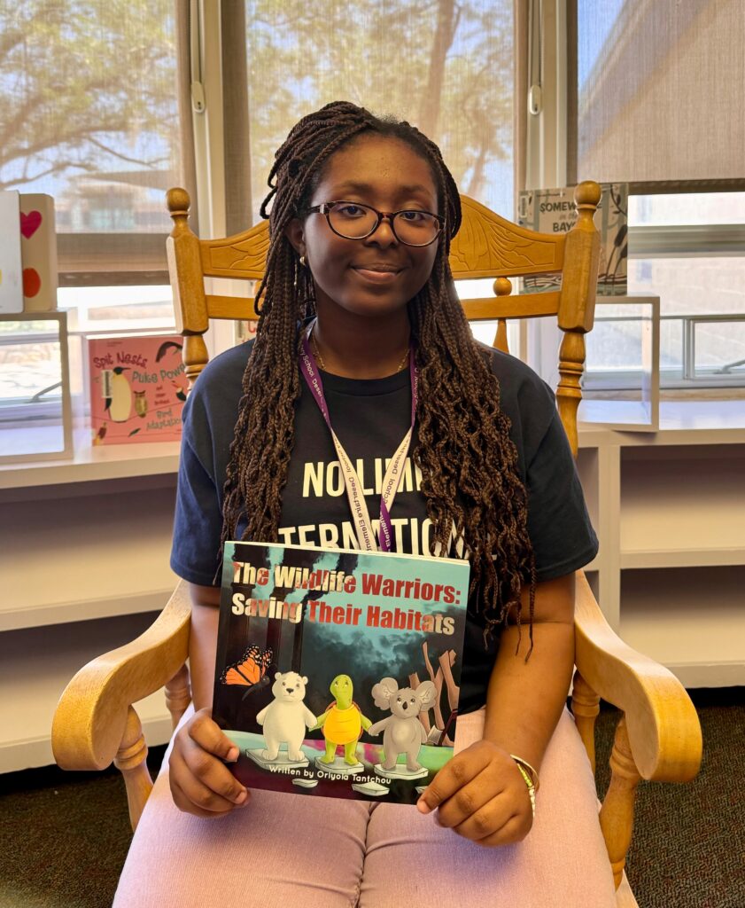 Orlyola Tantchou holds a copy of her children’s book, “The Wildlife Warriors: Saving Their Habitats,” during No Limit International’s visit to a local school in El Paso, Texas.